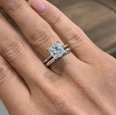 a woman's hand with a diamond ring on her left and an engagement band on her right