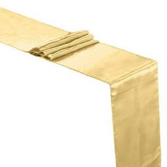 a gold table runner with folded napkins on it