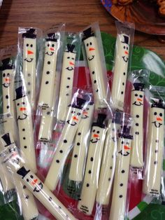 six white snowman toothbrushes wrapped in plastic wrappers with the words winter snack written on them