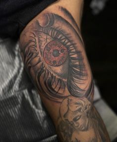 a man's arm with an eye tattoo on it and a lion behind him