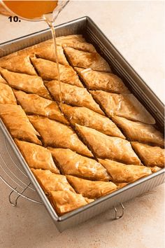 a pan filled with pastry sitting on top of a counter next to a glass of orange juice