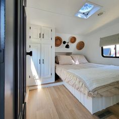 there is a bed in the room with white walls and wood flooring on the side