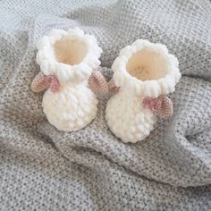 two knitted baby booties laying on top of a blanket