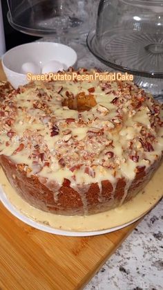 a cake sitting on top of a wooden cutting board next to a glass dish cover