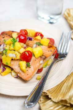 a white plate topped with fish and pineapple salsa