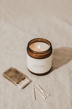 a candle and matches sitting on a bed