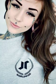 a woman with tattoos and piercings on her face