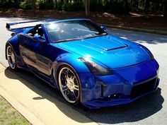 a blue sports car is parked on the street