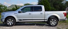 a silver truck parked on top of a gravel road