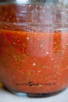 a jar filled with red sauce sitting on top of a counter