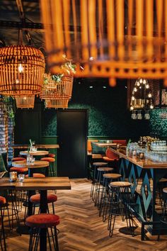 the interior of a restaurant with many tables, chairs and lights hanging from the ceiling