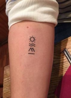 a woman with a tattoo on her arm that has the word om written in cursive writing