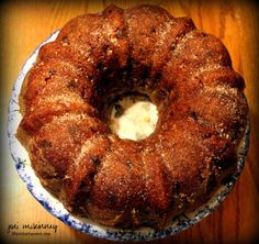 a bundt cake sitting on top of a blue and white plate next to a wooden table