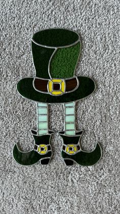 a green hat and boots are on the carpet