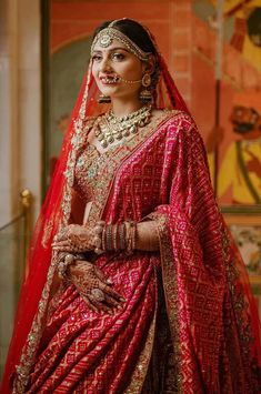 a woman in a red and gold bridal outfit