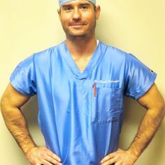 a man in scrubs standing with his hands on his hips