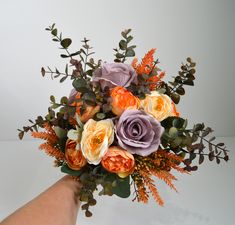 a hand holding a bouquet of flowers on a white background