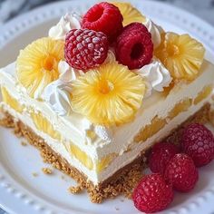 a white plate topped with a piece of cake covered in whipped cream and raspberries