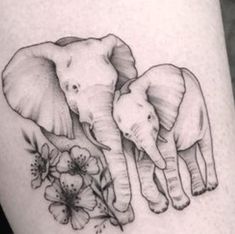 an elephant and her baby are depicted on the thigh, with flowers around them in black and white