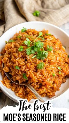 a white bowl filled with rice and garnished with cilantro on top