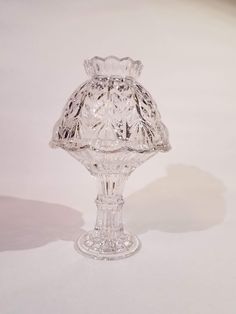 a clear glass vase sitting on top of a white table