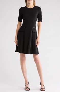 Zippered trims and front-flap pockets bring style points to this stem-baring dress cut in a timeless A-line silhouette. 36 1/2" length (size 6) Exposed back-zip closure Jewel neck Short sleeves Front flap pockets Partially lined 96% polyester, 4% spandex Dry clean Imported Black A-line Dress With Pockets, Seamed Knee-length Dress For Work, Knee-length Seamed Workwear Dress, A-line Office Dress With Pockets, Seamed Midi Dress For Work, Seamed Midi-length Workwear Dresses, Seamed A-line Dress For Work, A-line Mini Dress With Back Zipper For Work, Seamed Midi Length Work Dresses