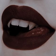 a woman's lips with white teeth and dark lipstick