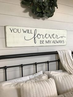 a bed with white sheets and pillows under a sign that says you will forever be my always