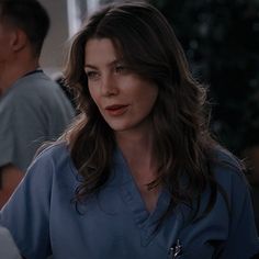 a woman in scrubs sitting at a table