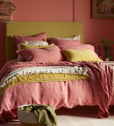 a bedroom with pink walls and yellow bedding