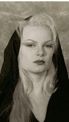 black and white photograph of a woman with long blonde hair, wearing a black robe