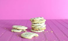 a stack of cookies sitting on top of a purple table next to a pink wall