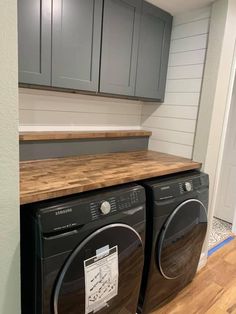 a washer and dryer in a room with wood flooring on the side