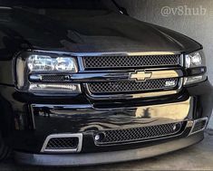 the front end of a black truck parked in a garage