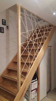 a wooden stair case next to a white wall