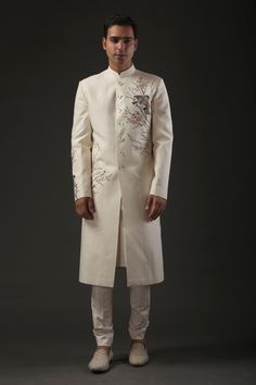 Ivory matka silk sherwani with resham and zari embroidery in floral, bird motifs and silk lined.
Component: 1
Pattern: Embroidered
Type Of Work: Resham, Zari
Neckline: Mandarin
Sleeve Type: Full
Fabric: Matka Silk, Lining: Silk 
Color: Ivory
Other Details: 
Resham and zari work
Note: Pant and inner kurta worn by the model is not for sale
Occasion: Groom,Wedding - Aza Fashions Ceremonial Cream Bandhgala In Raw Silk, Designer Cream Nehru Jacket For Ceremonial Occasions, Designer Embroidered Cream Kurta, Designer White Raw Silk Sherwani, Designer Sherwani With Floral Embroidery For Wedding, Designer Off-white Bandhgala With Resham Embroidery, Cream Embroidered Sherwani For Ceremonial Occasions, Designer Embroidered Cream Bandhgala, Designer Embroidered Silk Sherwani