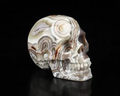 a marbled skull on a black background with white and brown swirls in the middle