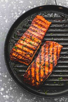 two pieces of grilled salmon on a grill