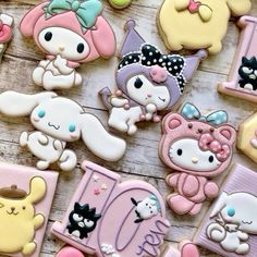 many decorated cookies on a wooden table with one being a cat and the other is a dog