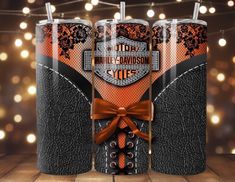 an orange and black harley davidson gift box with two glasses in it, on top of a wooden table