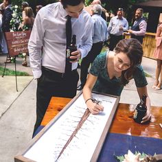 a man and woman looking at a table with writing on it