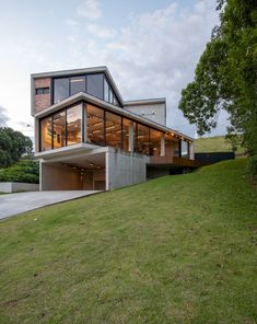 the modern house is built on top of a hill with grass and trees around it