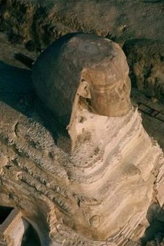 an aerial view of the head of a statue on display in front of some rocks