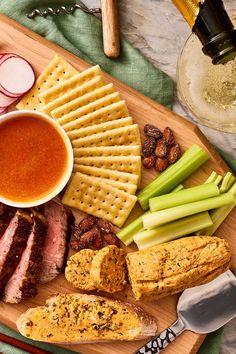 a platter with meat, crackers and vegetables