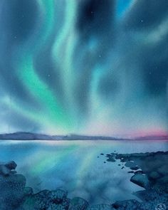 an aurora bore over the ocean with rocks in front of it and green, purple, and blue lights