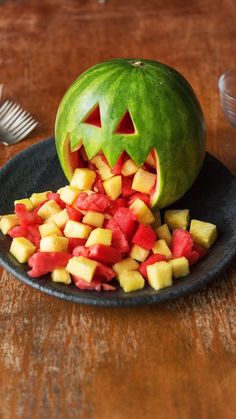 a carved pumpkin is sitting on a plate with chopped fruit in it's mouth