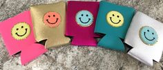 four different colored wallets sitting on top of a marble counter with faces drawn on them