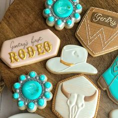 decorated cookies are arranged on a wooden table with cowboy hats and other items in the background