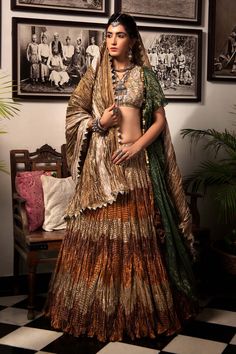 Multicolored gota tissue textured lehenga with bronze, rust and antique gold panels. Paired with zardozi beige blouse, one-sided ruffled jacket.
Component: 3
Pattern: Textured
Neckline: V neck
Fabric: Gota Tissue
Color: Multi Color
Other Details: 
Textured lehenga
Tassel detail
Note: Crushed dupatta worn by the model is not for sale
Occasion: Sangeet, Destination Wedding - Aza Fashions Bohemian Raw Silk Choli For Wedding, Bohemian Style Semi-stitched Raw Silk Lehenga, Bohemian Raw Silk Choli With Dupatta, Bohemian Festive Raw Silk Lehenga, Festive Bohemian Raw Silk Lehenga, Festive Brown Pre-draped Saree For Wedding, Gold Brocade Sets With Gota Work, Bohemian Raw Silk Lehenga With Dupatta, Bohemian Silk Lehenga With Mirror Work