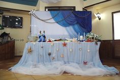 the table is set up for an ocean themed party with starfish and seashells